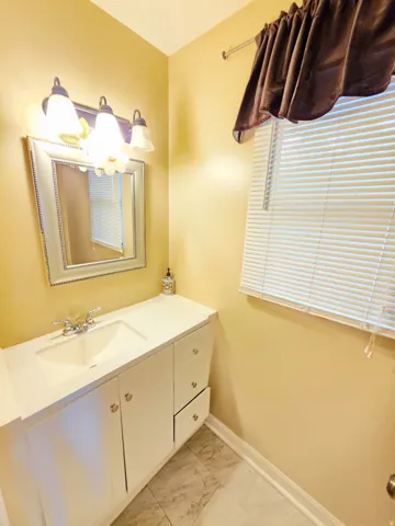 White vanity with an integrated sink, chrome faucet, and ample storage