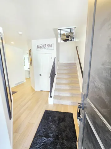Light wood-finish flooring with a carpeted staircase