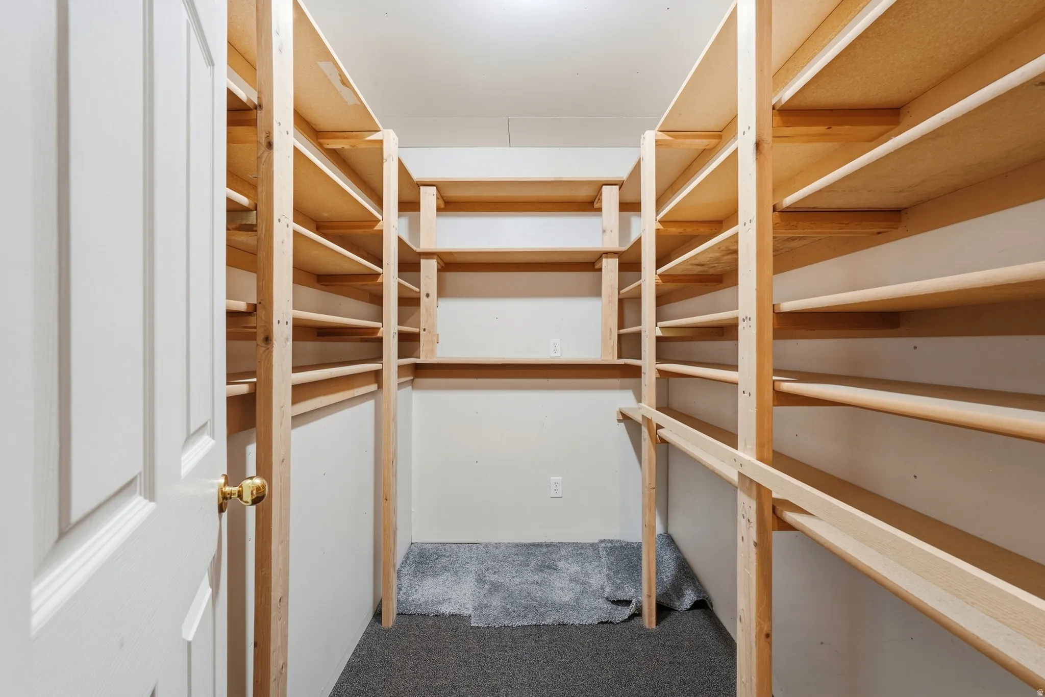Walk-in closet featuring extensive built-in wooden shelving