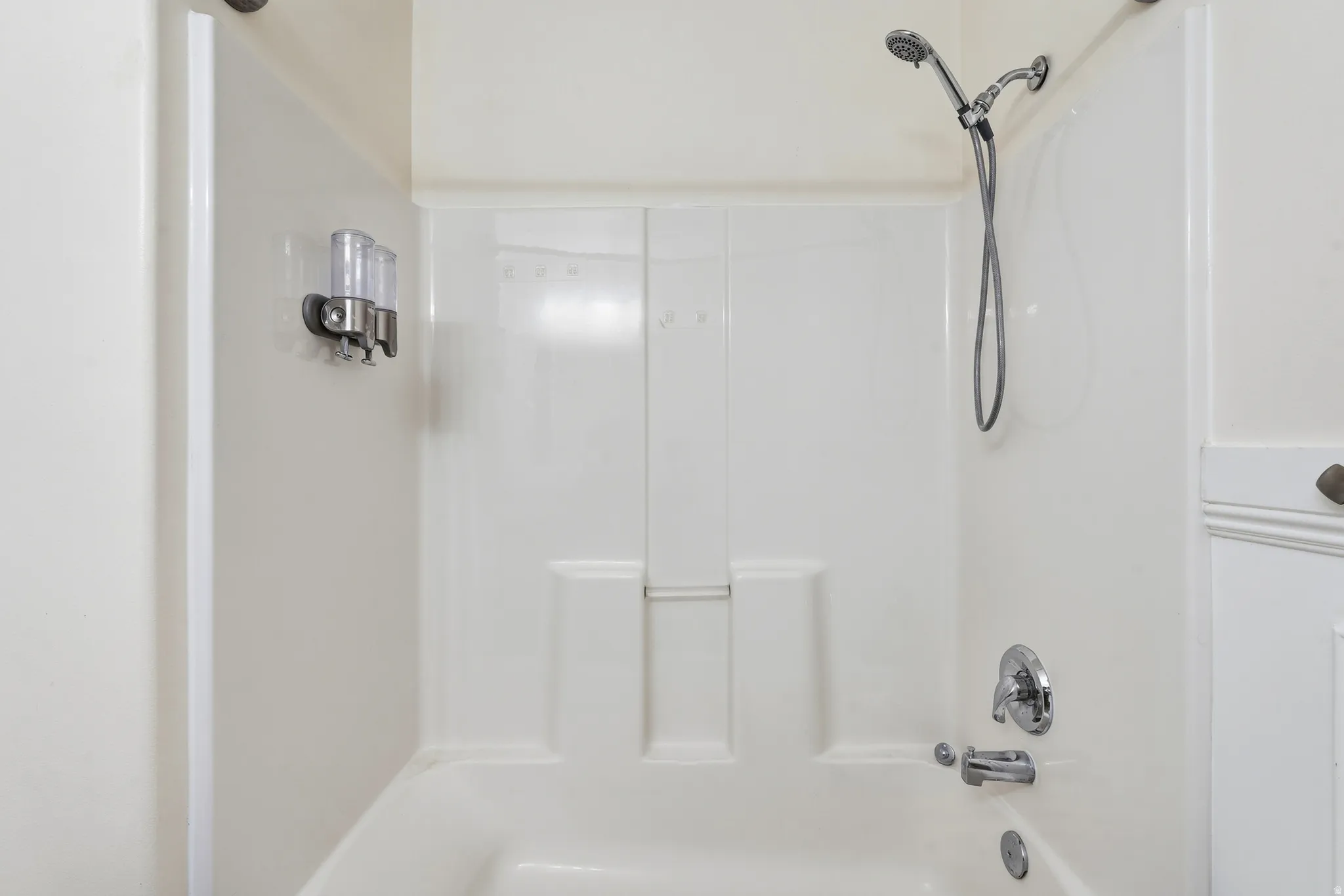 Bathtub with integrated shower surround and chrome fixtures