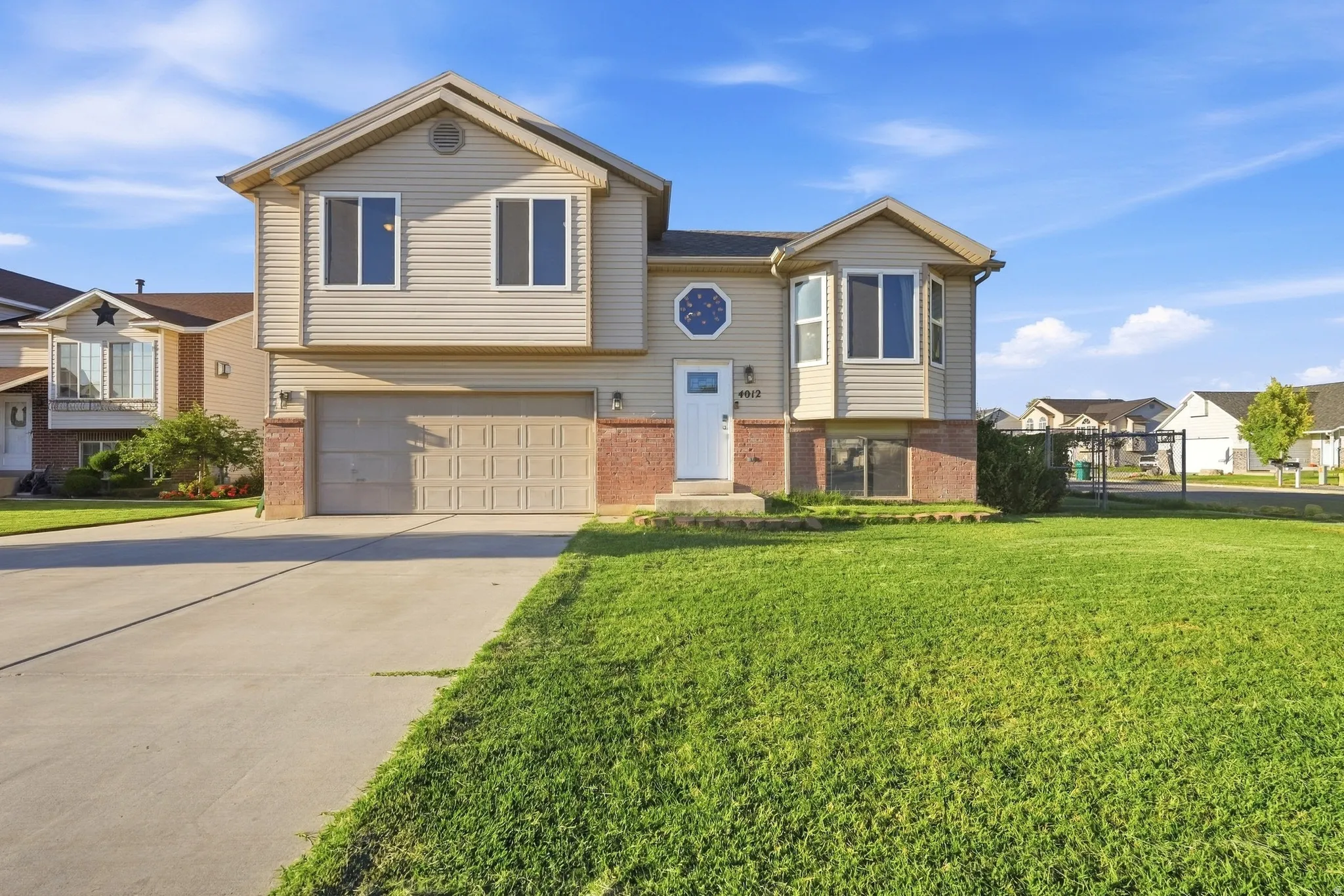 Two-story residence with a two-car garage, bay window, and a circular decorative window