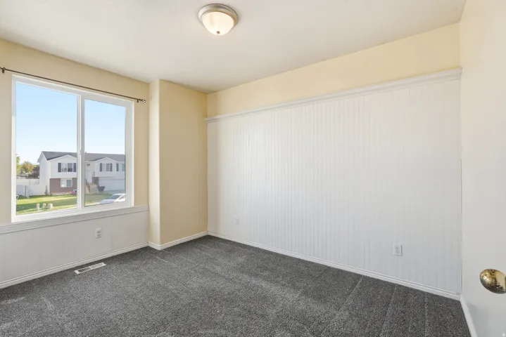 White beadboard wainscoting, neutral tone walls, recessed ceiling light, and gray carpet flooring