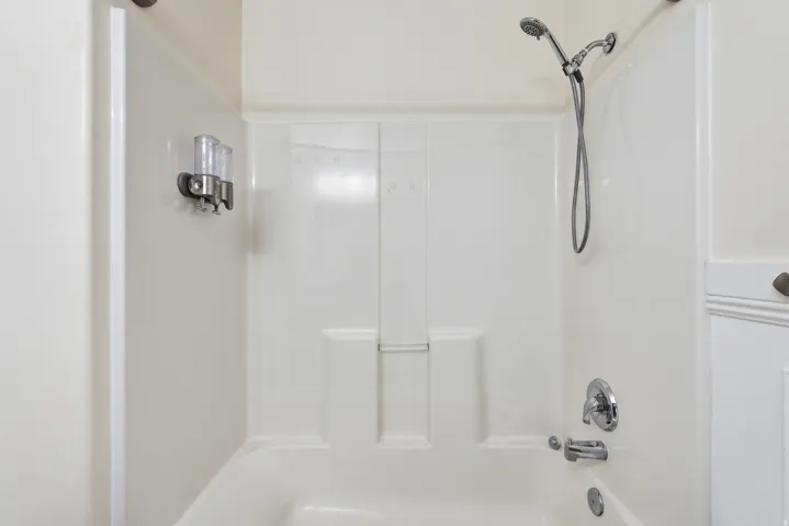 Bathtub with integrated shower surround and chrome fixtures
