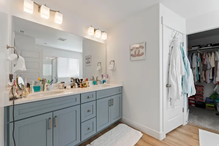 Double vanity with light blue cabinetry and brushed nickel hardware