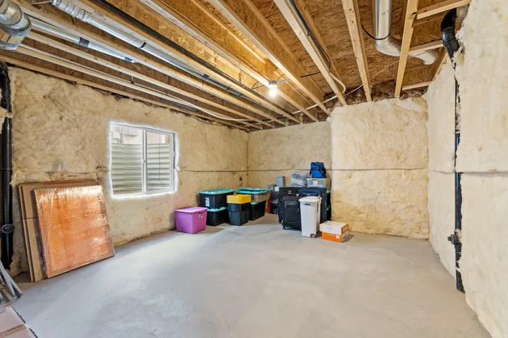 Daylight basement with exposed joists, concrete flooring, and insulated walls