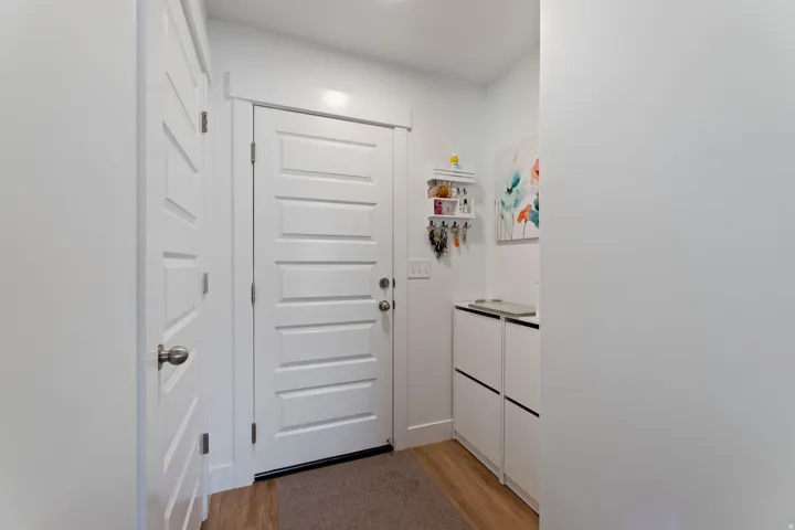 White paneled interior doors, wood-finish flooring, and built-in storage units