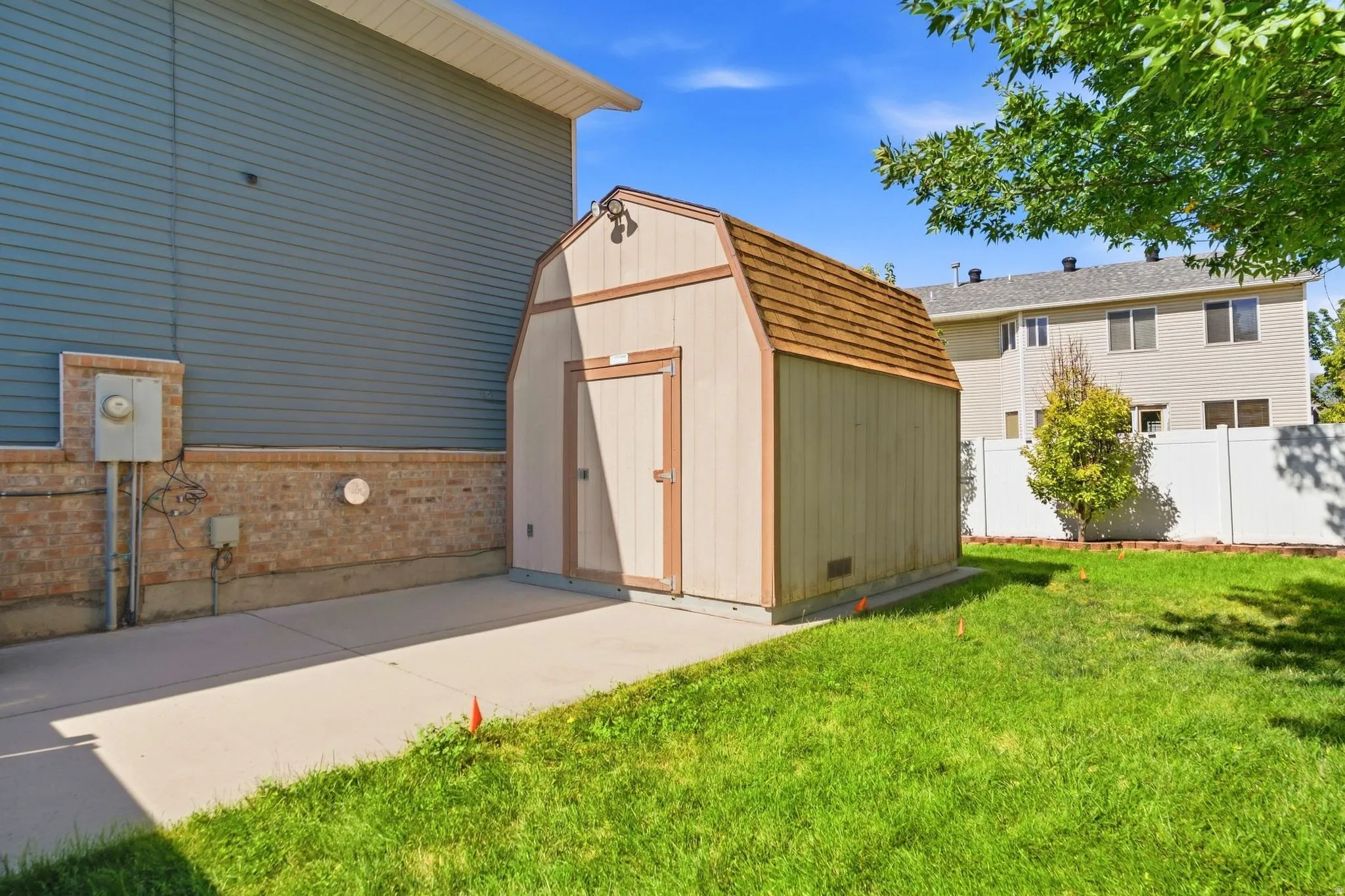Extra-long RV pad extends behind the fence into the backyard, with access to an additional oversized storage shed.