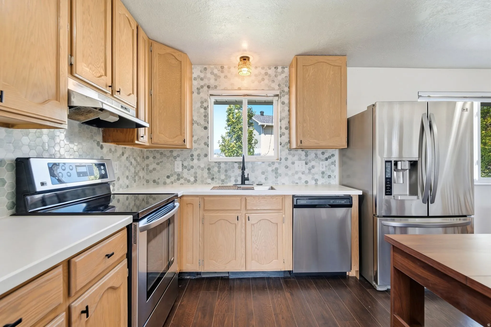 Beautiful kitchen with stainless steel appliances, quartz countertops, and a stylish tile backsplash.