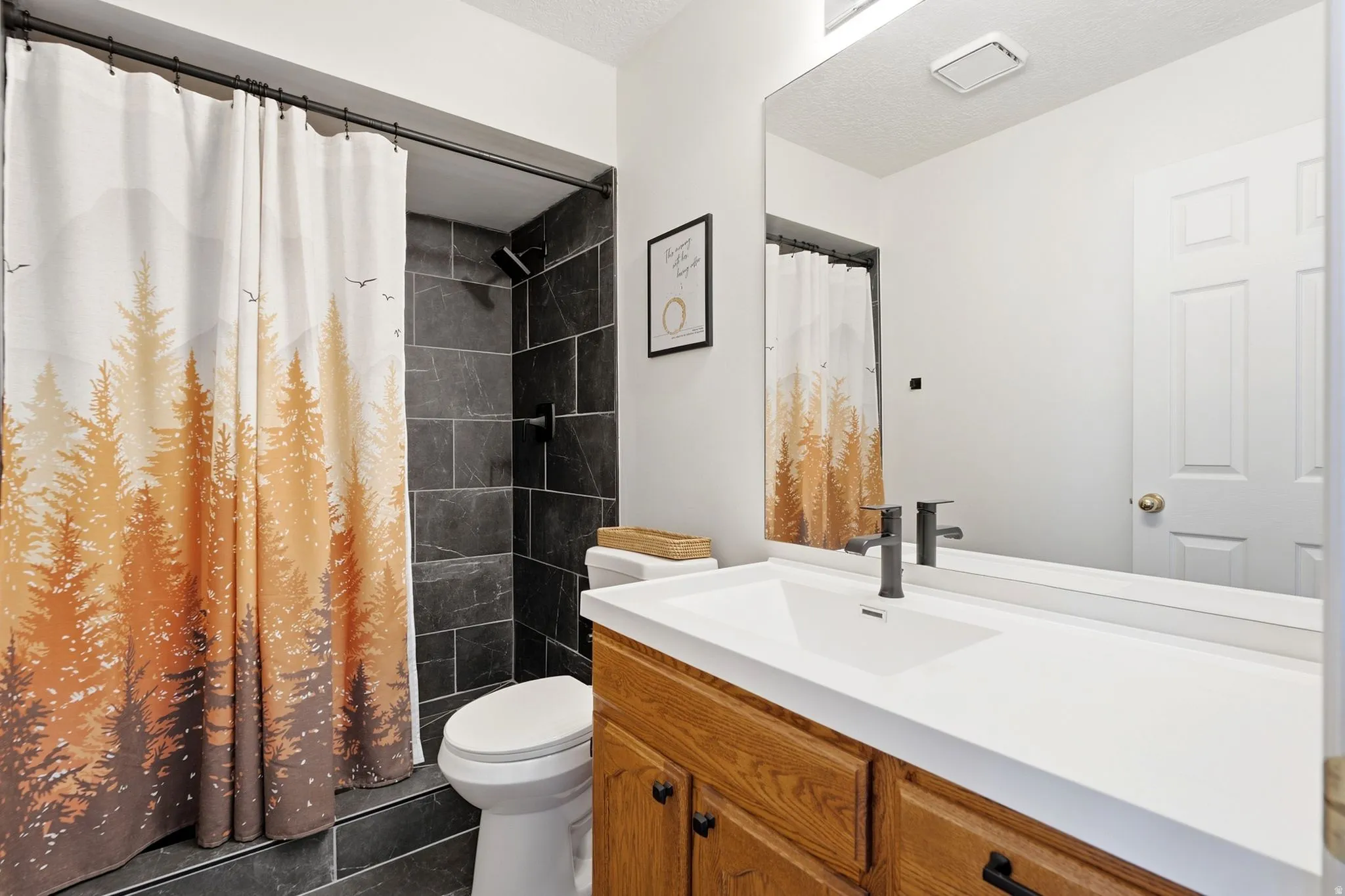 Beautifully updated primary bath featuring a custom tile shower and stylish vanity.