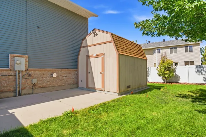 Extra-long RV pad extends behind the fence into the backyard, with access to an additional oversized storage shed.