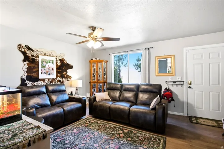 Recessed lighting, ceiling fan light fixture, wood-finish flooring, white paneled door, and a large window providing natural illumination