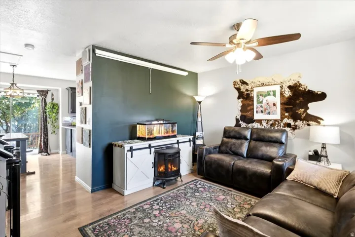 LVP flooring, ceiling fan with integrated lighting, recessed wall niche, built-in storage cabinet, and a freestanding electric stove