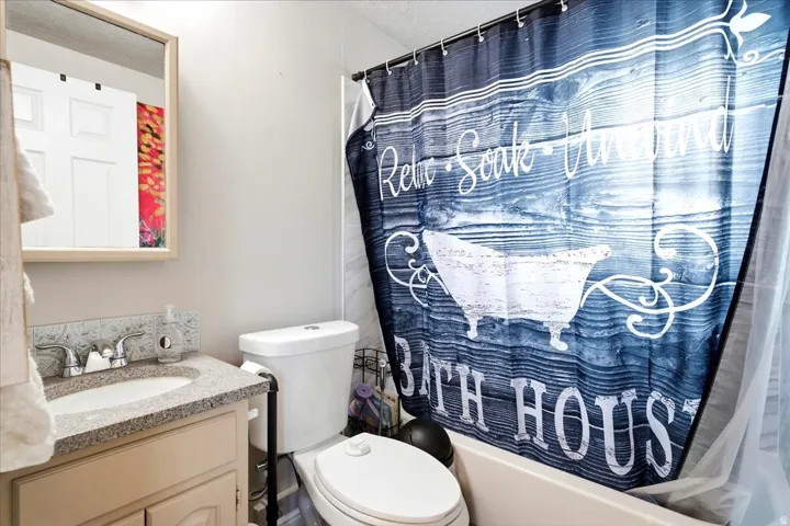Bathroom featuring a single vanity with a light-colored countertop, an undermount sink, and chrome fixtures