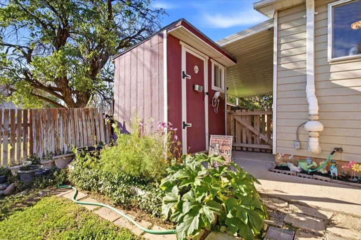 Red-sided outdoor storage shed with a white-trimmed window