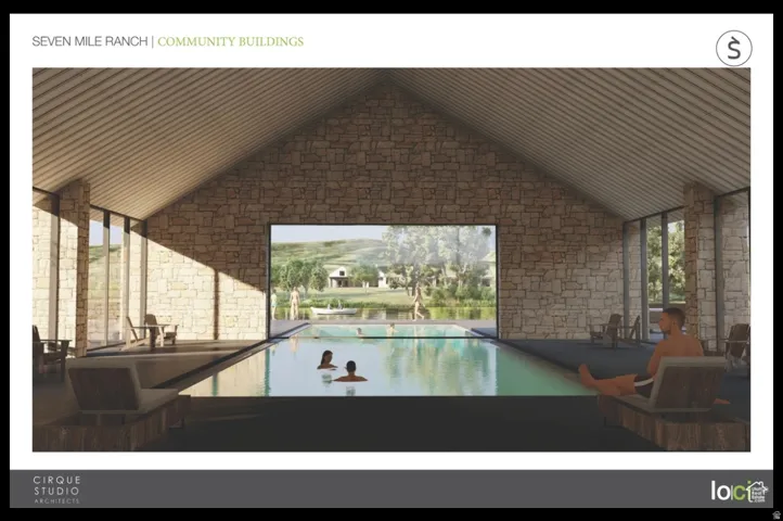 Indoor swimming pool with stone accent walls and a vaulted ceiling