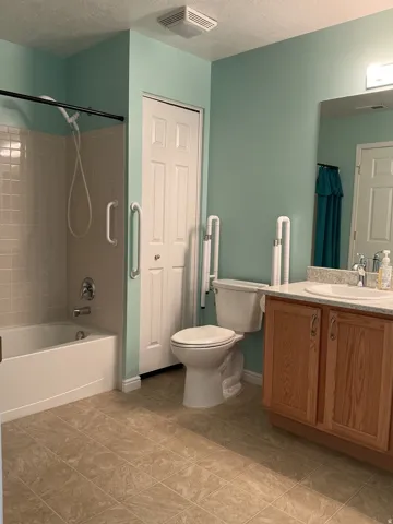 Tiled flooring and a built-in bathtub with tiled surround