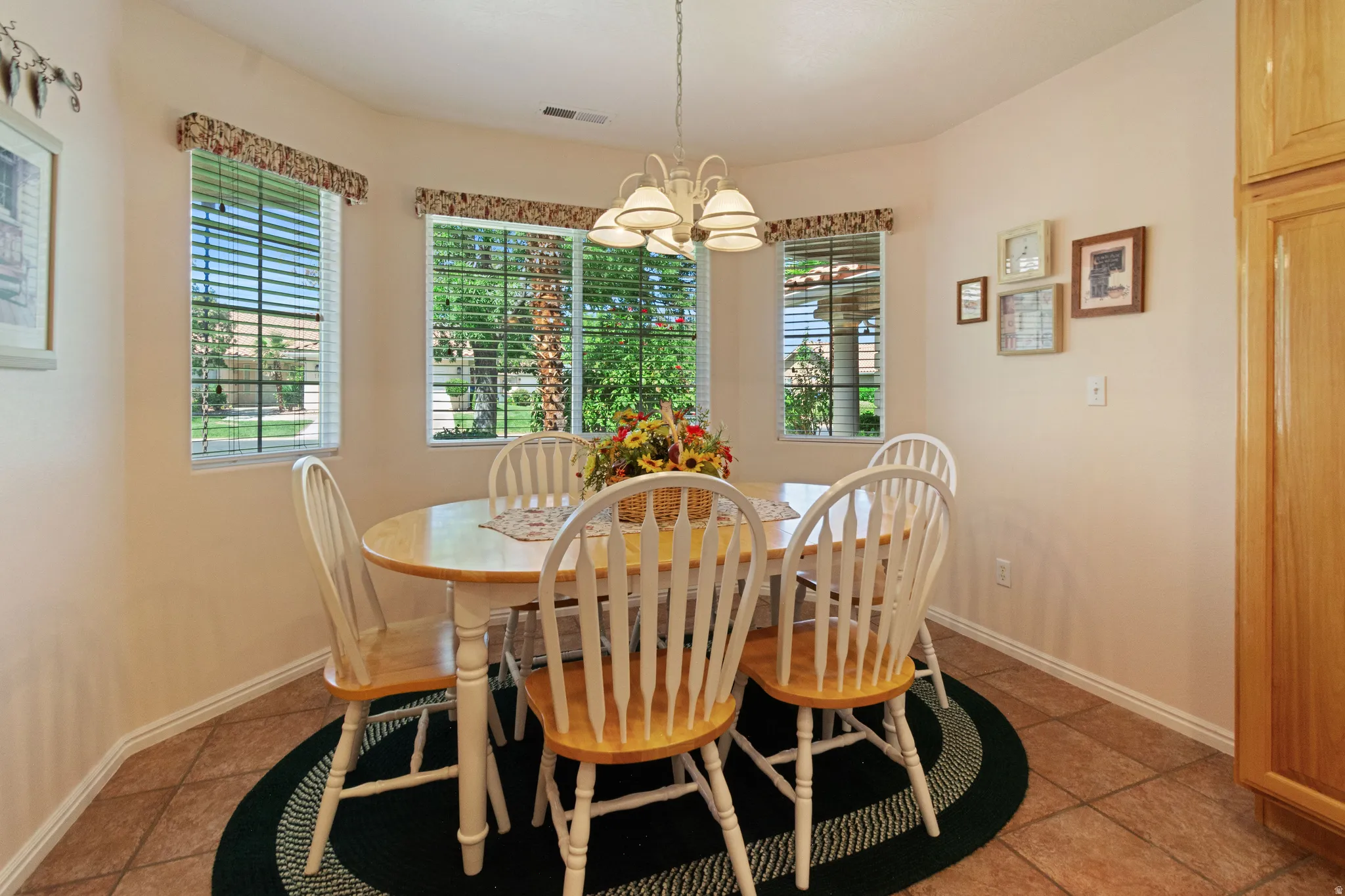 Bay window dining area featuring tile flooring, a chandelier, and built-in cabinetry