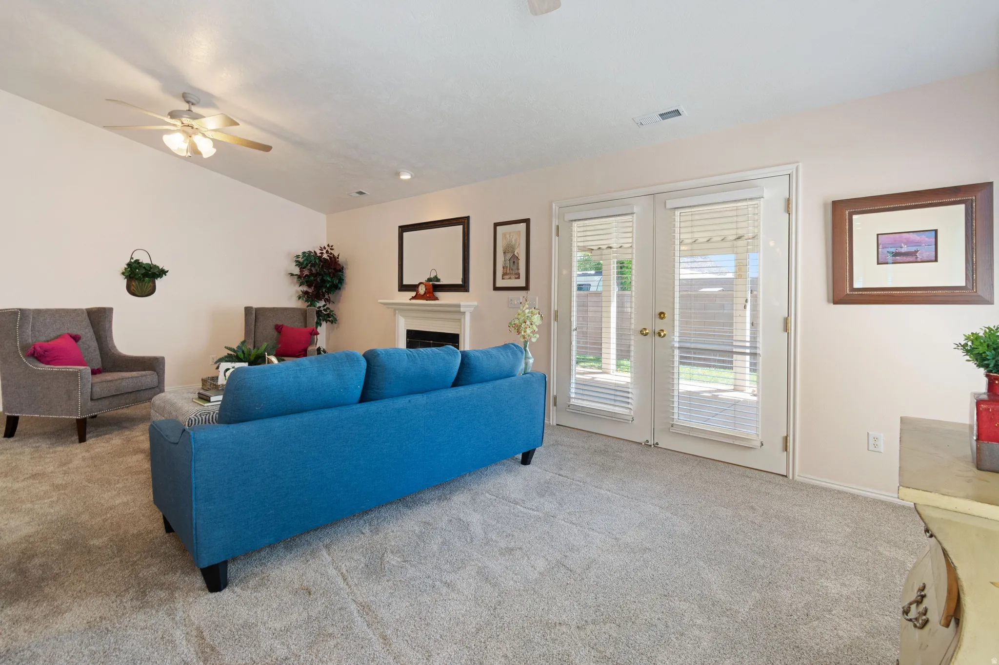 Vaulted ceiling with a ceiling fan, recessed lighting, and a fireplace with a mantel