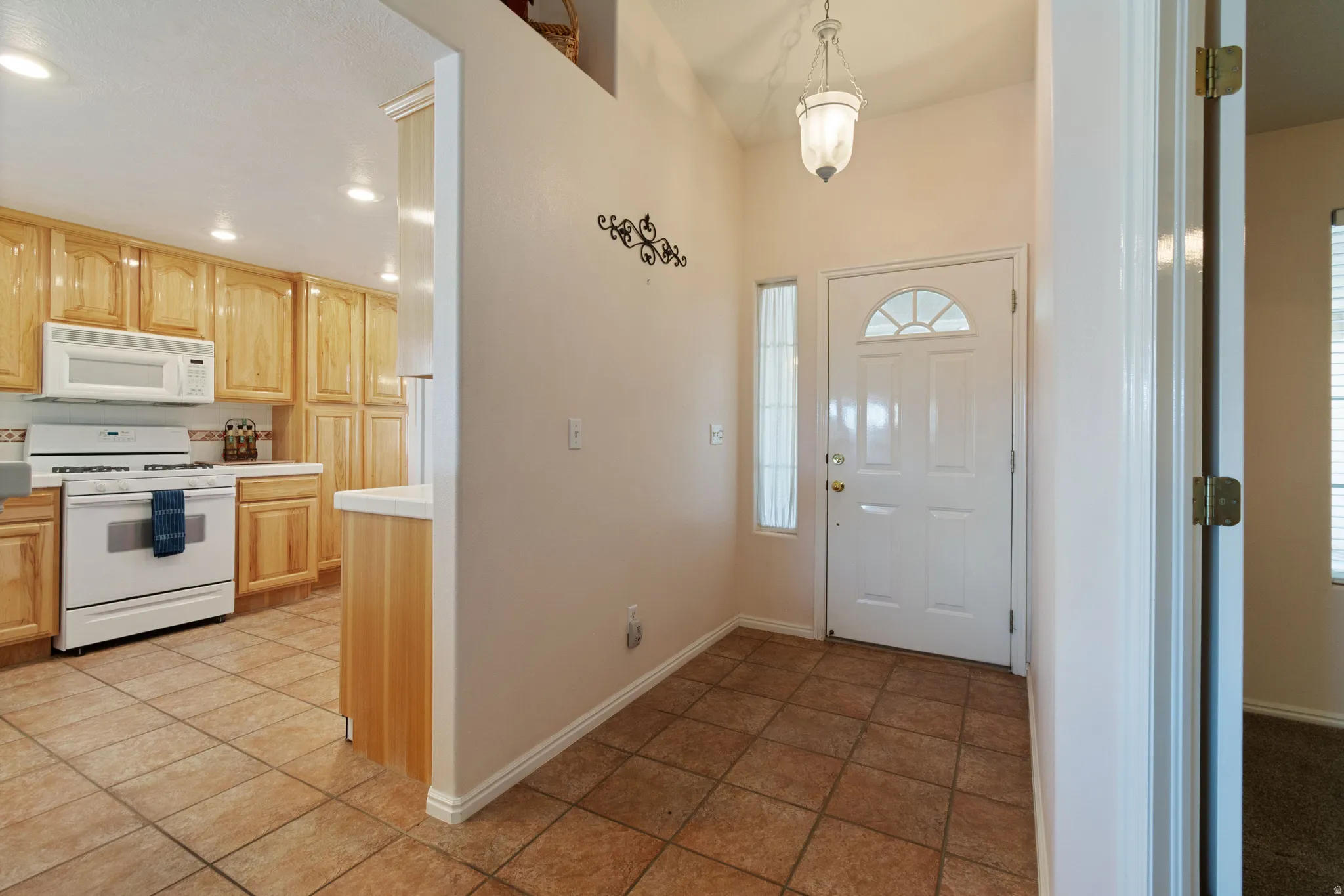 Entryway featuring a vaulted ceiling and tile flooring