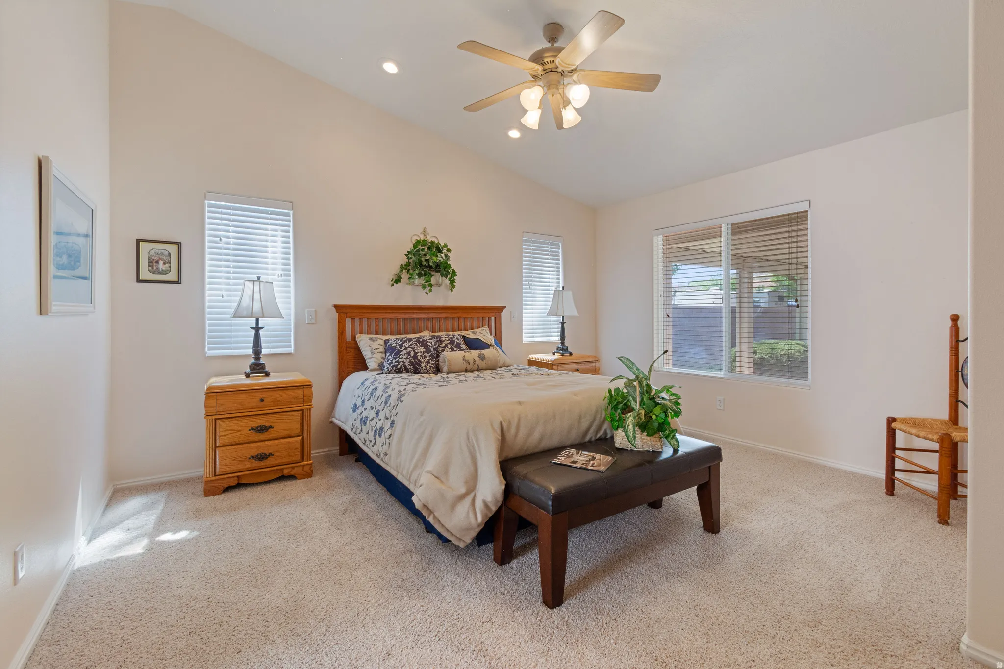 Vaulted ceiling with recessed lighting and ceiling fan, two windows with blinds, and carpeted flooring
