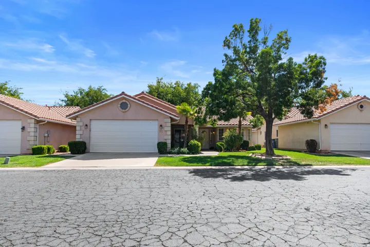 Single-story residence featuring a tile roof, an integrated garage, and a circular decorative window