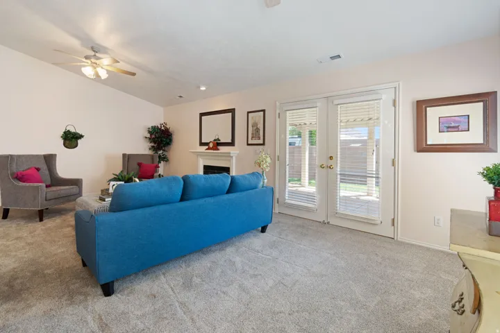 Vaulted ceiling with a ceiling fan, recessed lighting, and a fireplace with a mantel