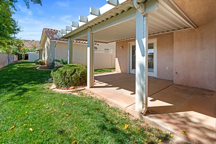 Covered patio with an attached pergola, stucco exterior, tile roofing, and a manicured lawn