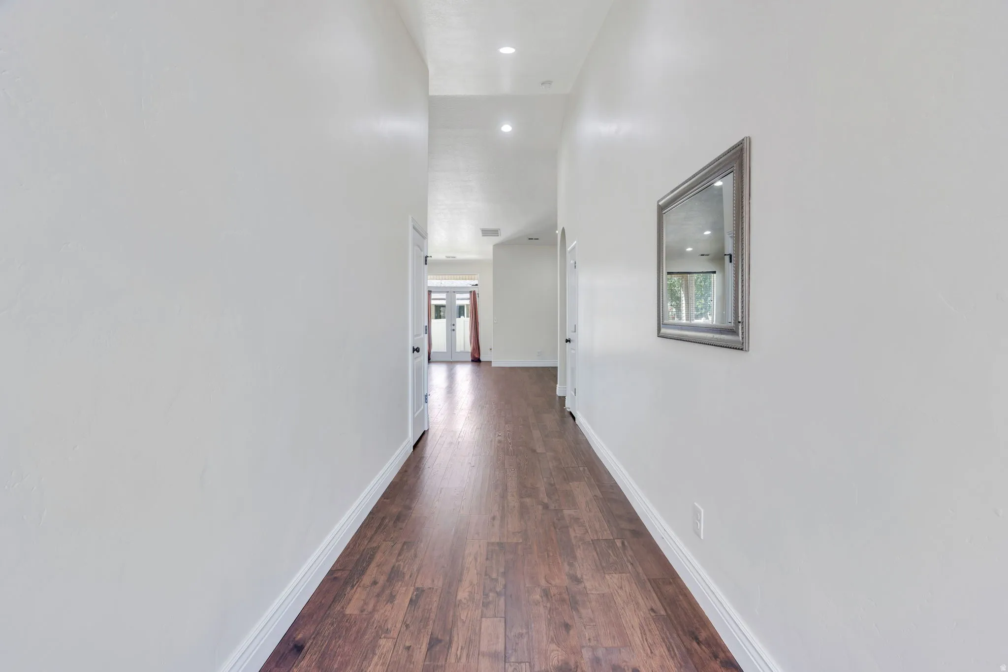 Wood-finish flooring, recessed lighting, and bright white walls