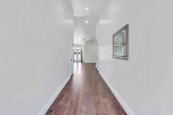 Wood-finish flooring, recessed lighting, and bright white walls