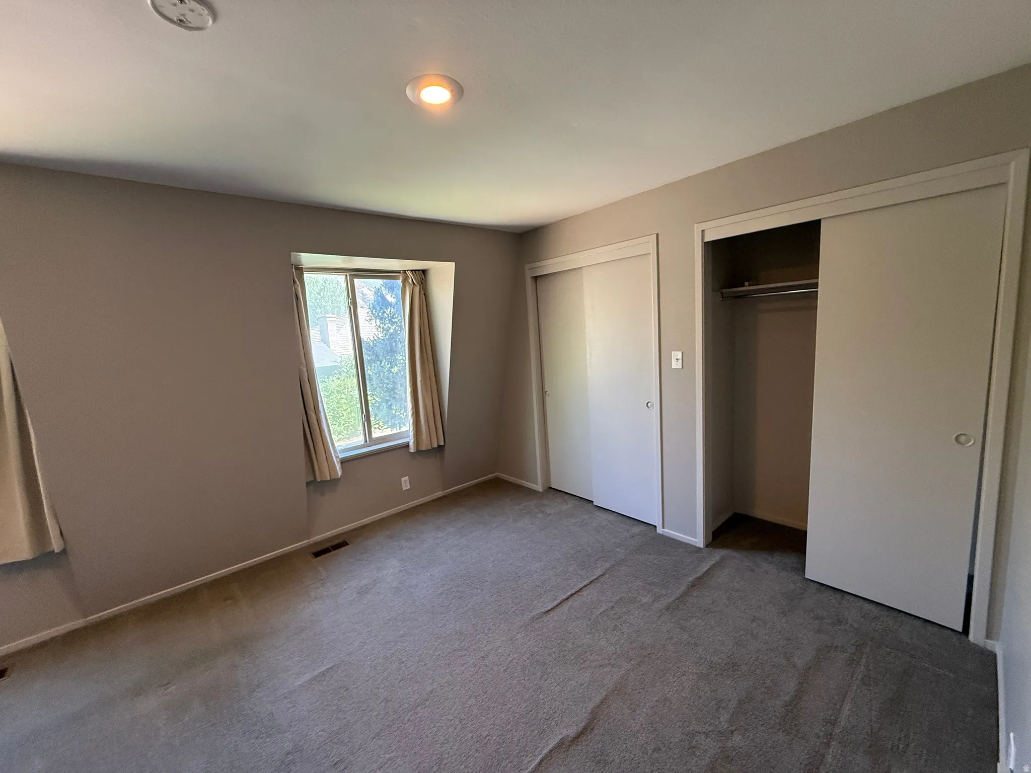Recessed lighting, window with trim, dual sliding closet doors, built-in closet rod, and carpet flooring