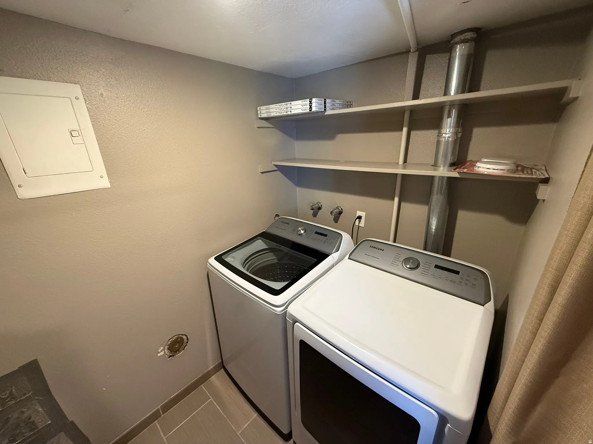 Utility area featuring two built-in shelves and tile flooring