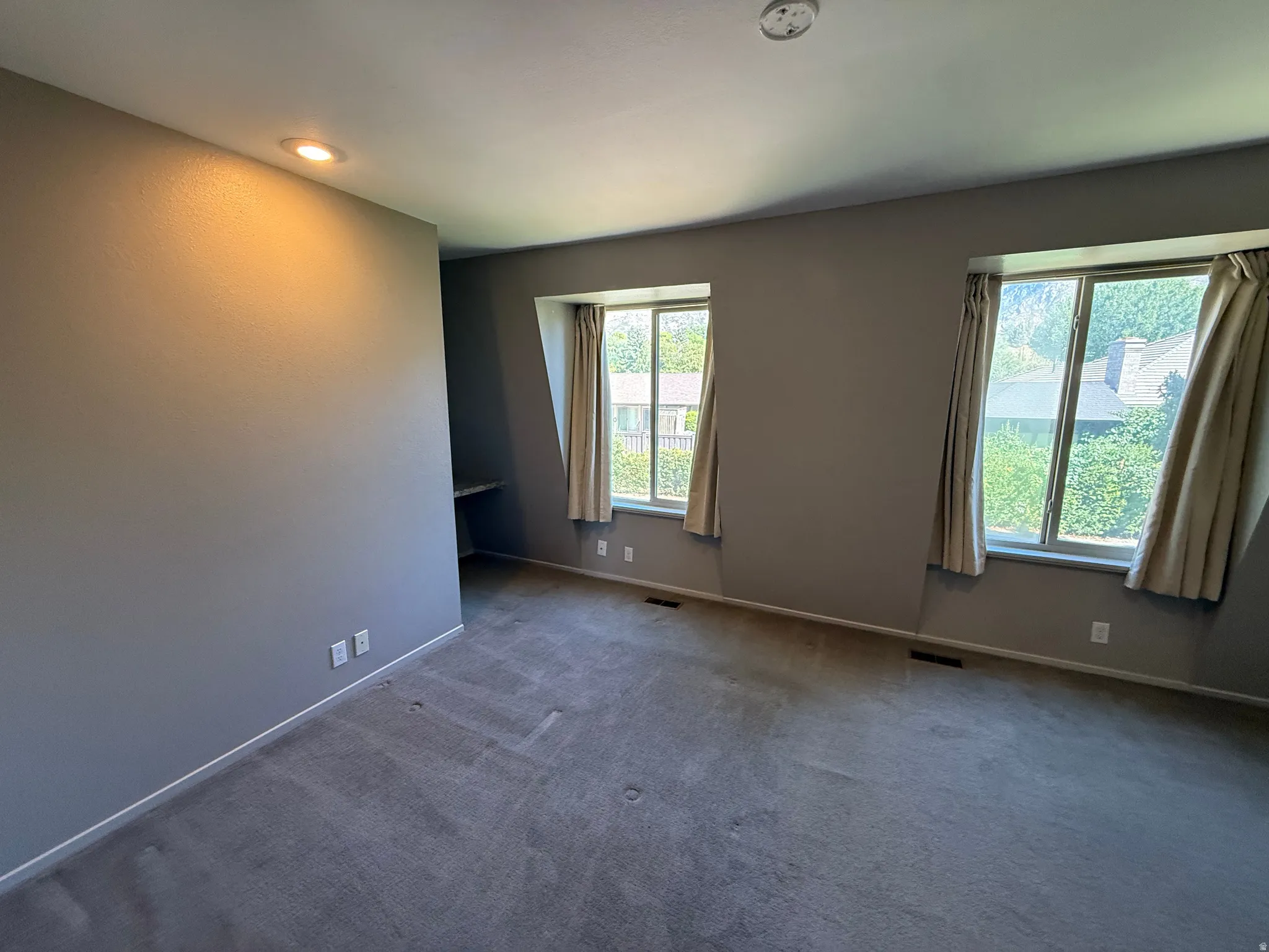 Wall-to-wall carpeting, recessed lighting, and three large windows