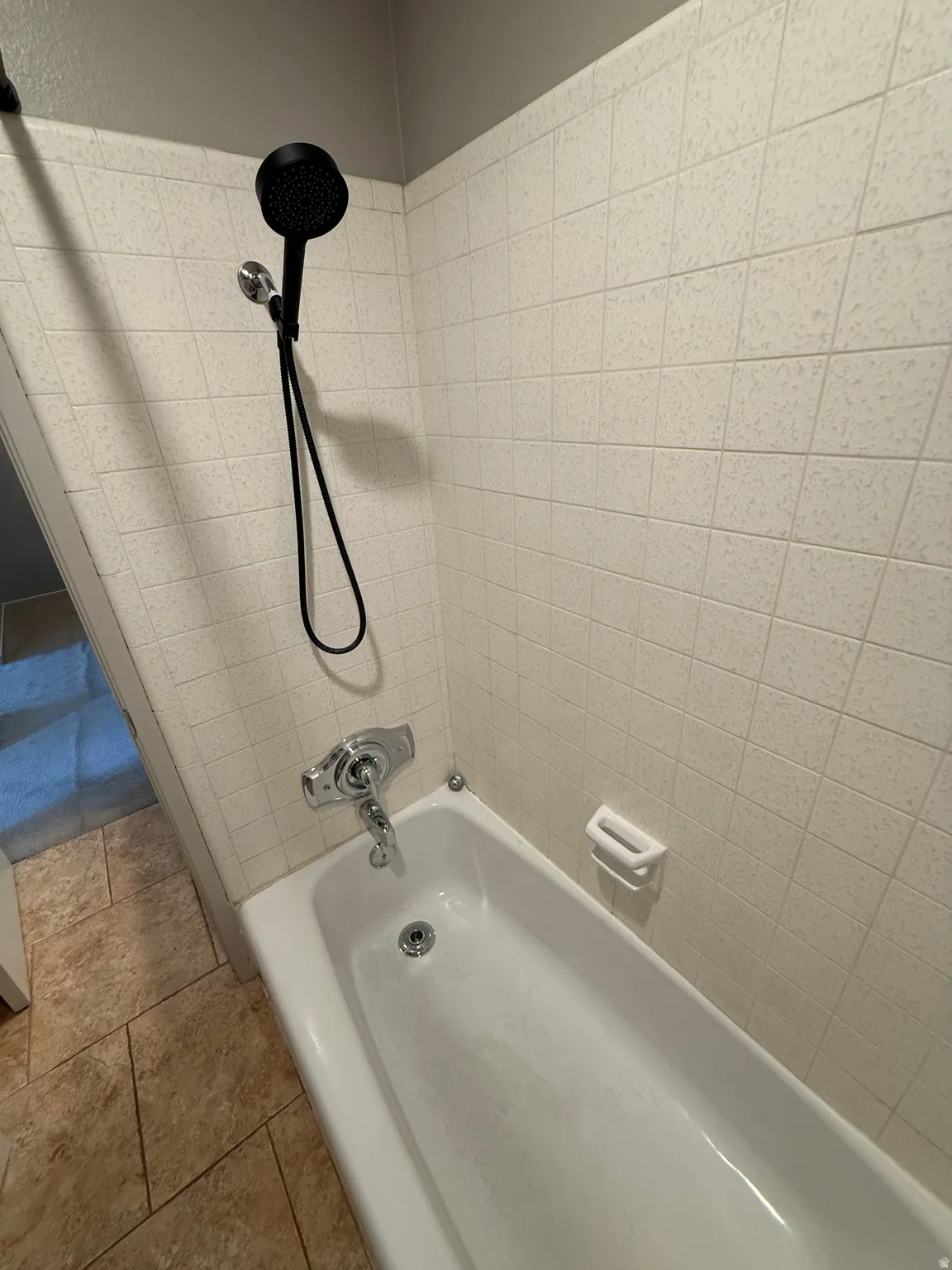 White bathtub with a matte black shower head and chrome fixtures