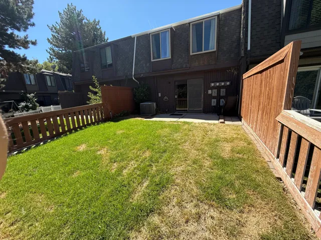Private fenced yard featuring a patio, sliding glass door access, and wood-paneled exterior