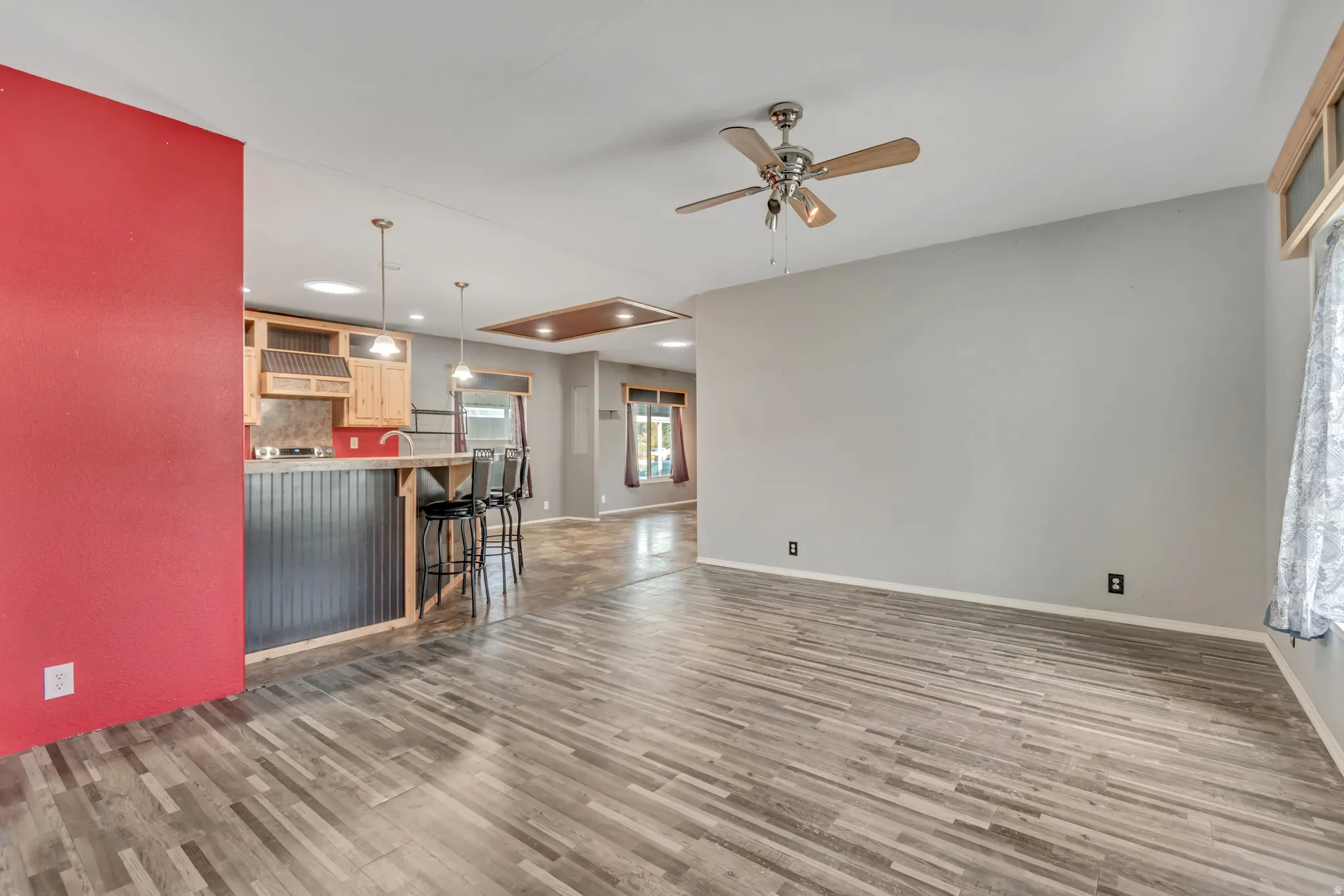 Wood-finish flooring throughout, ceiling fan with light fixture, and recessed lighting