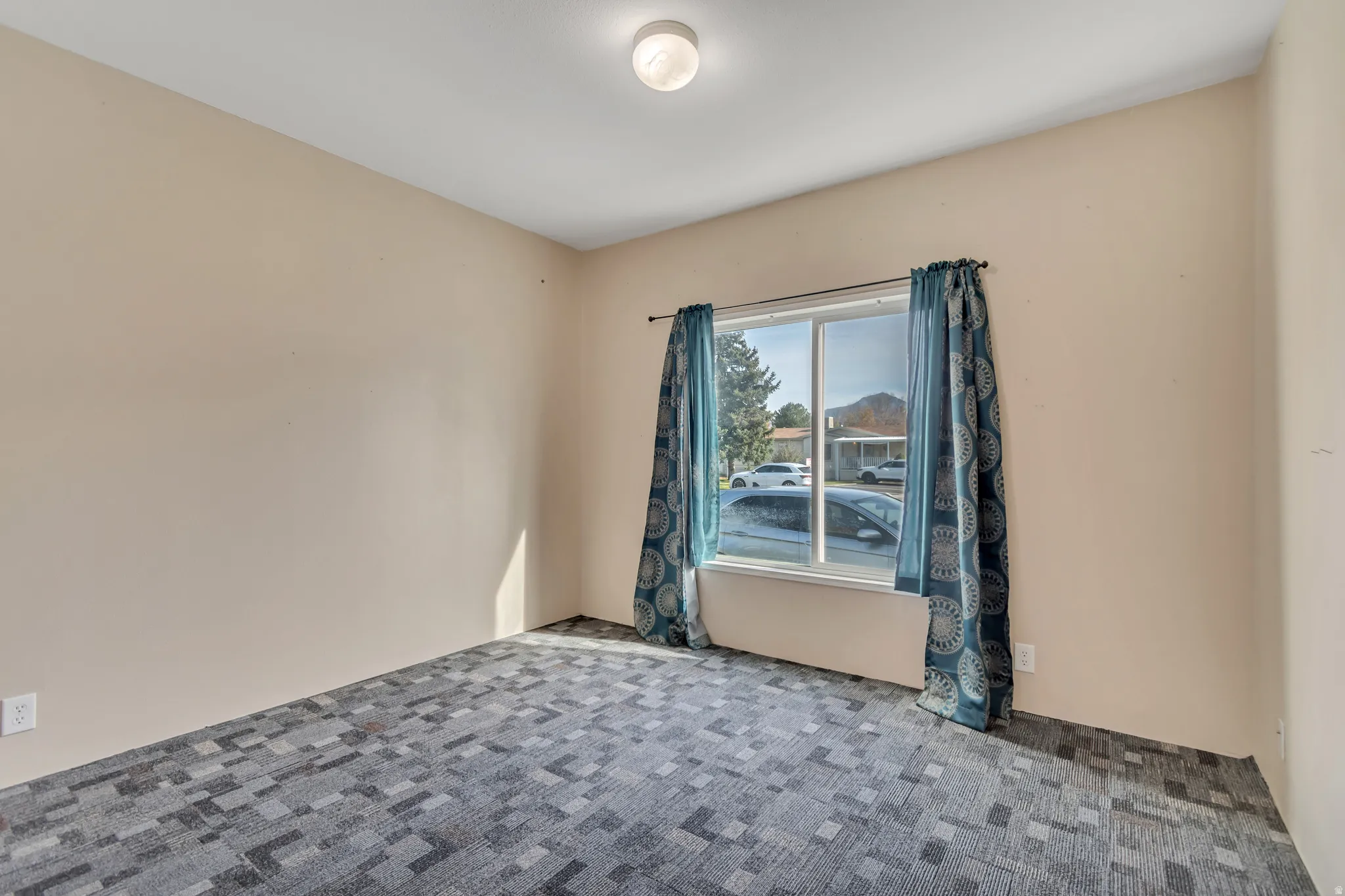 Recessed lighting, large window, and patterned carpet flooring