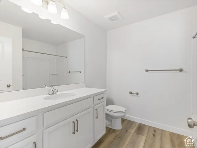 Vanity with a solid surface countertop, integrated sink, and white cabinetry