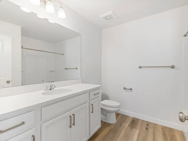 Vanity with a solid surface countertop, integrated sink, and white cabinetry