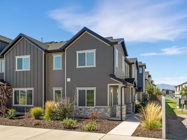 Contemporary exterior featuring mixed siding, stone accents, and dark-framed windows