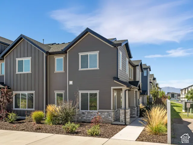Contemporary exterior featuring mixed siding, stone accents, and dark-framed windows