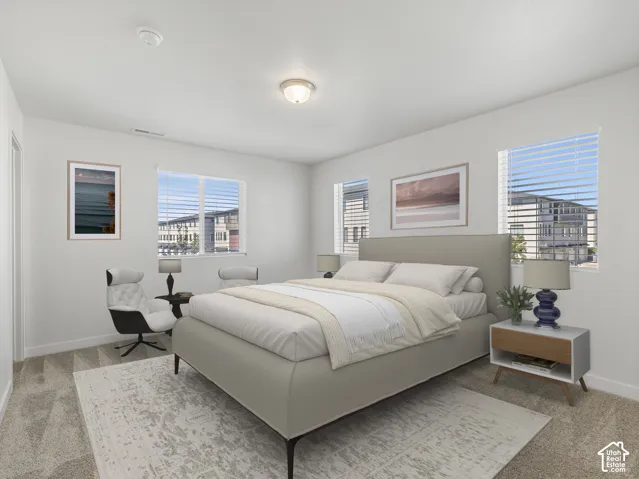 Bright room featuring multiple windows with blinds, carpeted flooring, and a flush-mount ceiling light fixture