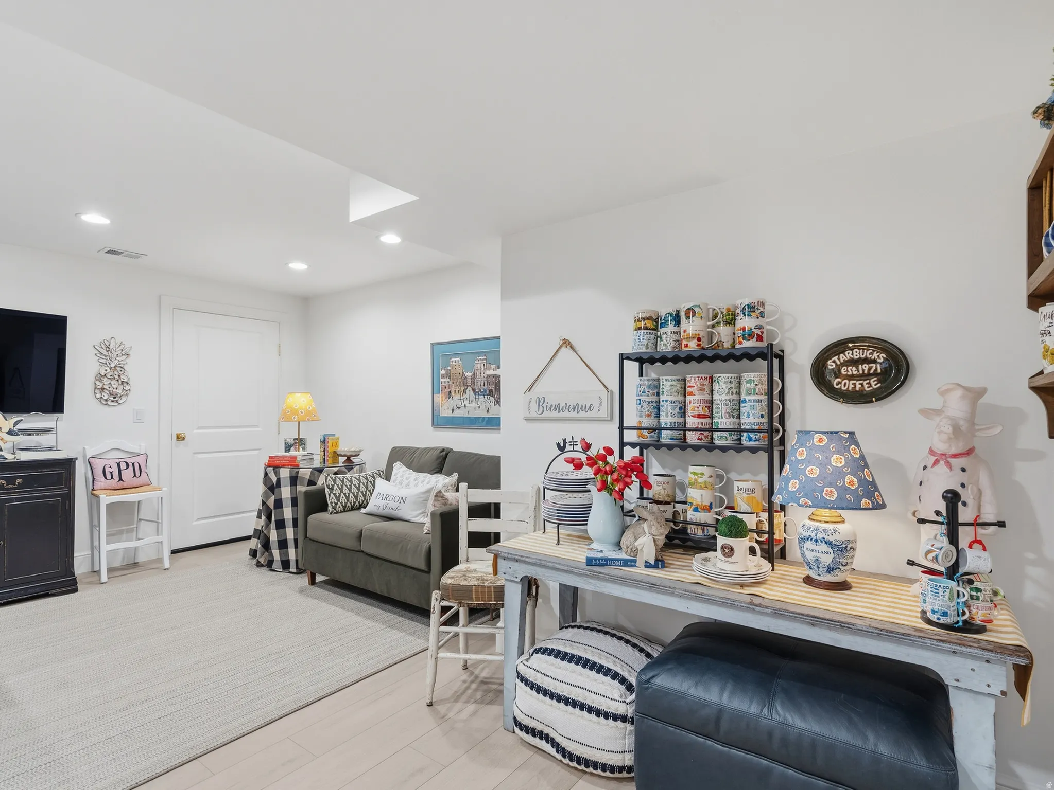 Recessed ceiling lighting, wood-finish flooring, white paneled door, and white painted walls
