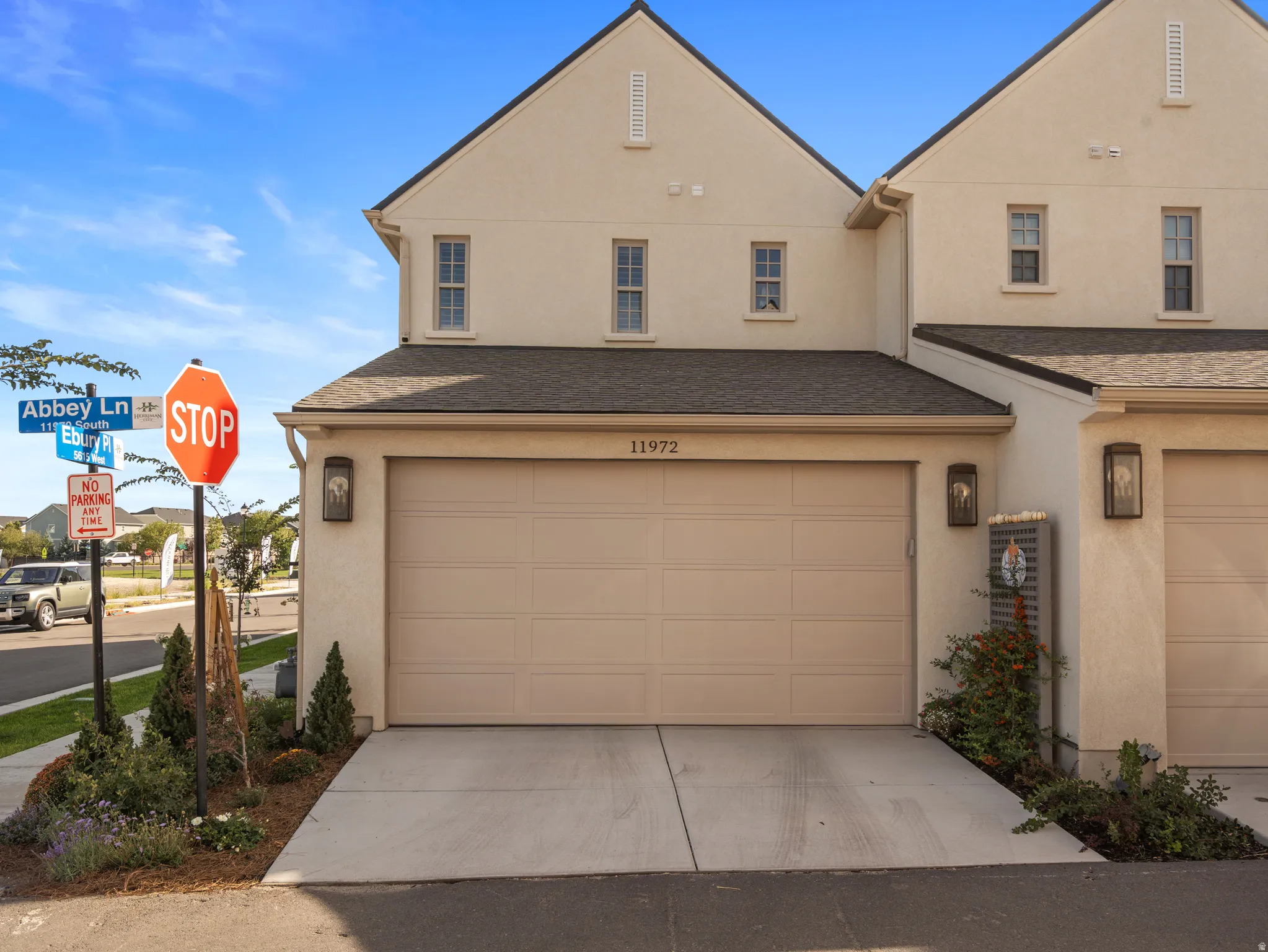 Stucco exterior with multiple windows, an attached garage, and a concrete driveway