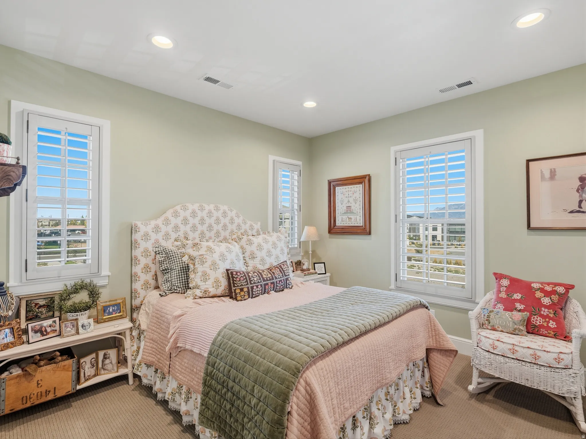Recessed lighting, light-toned carpeting, and multiple windows with plantation shutters