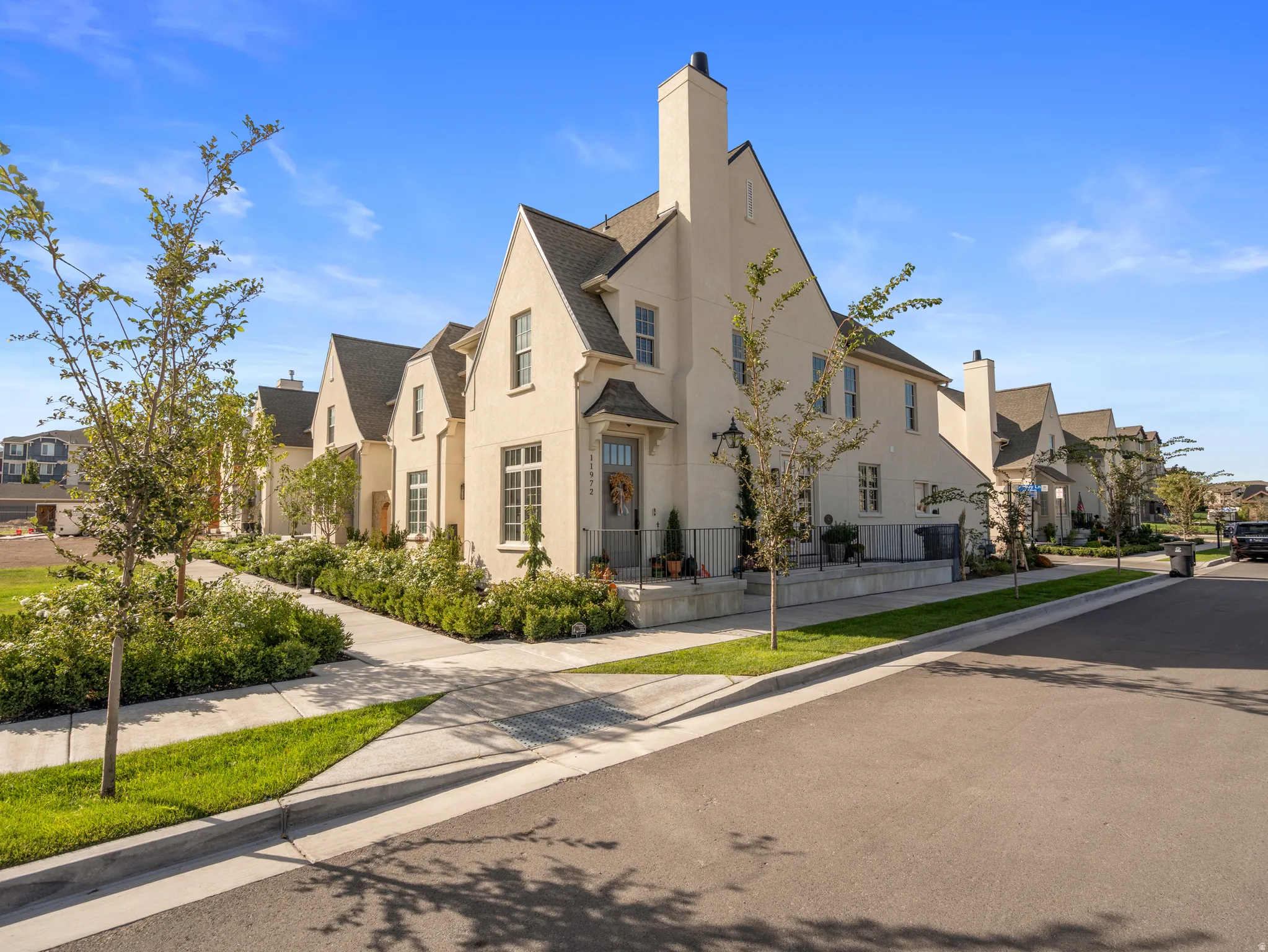 Stucco exterior with gabled roof lines, featuring multiple windows and a covered entry