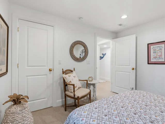 White interior doors, recessed lighting, and light-colored wall-to-wall carpeting