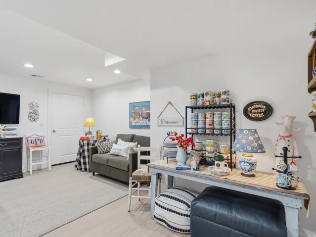 Recessed ceiling lighting, wood-finish flooring, white paneled door, and white painted walls