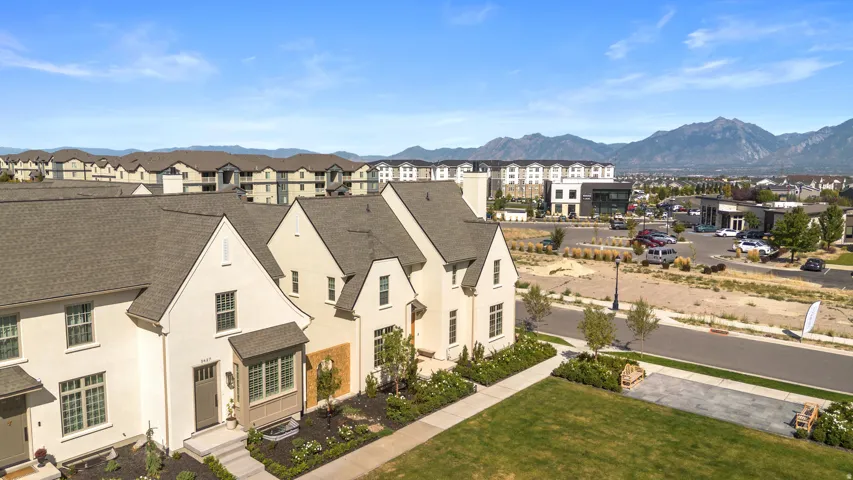 Contemporary townhome architecture featuring light-toned exteriors and dark gray roofs