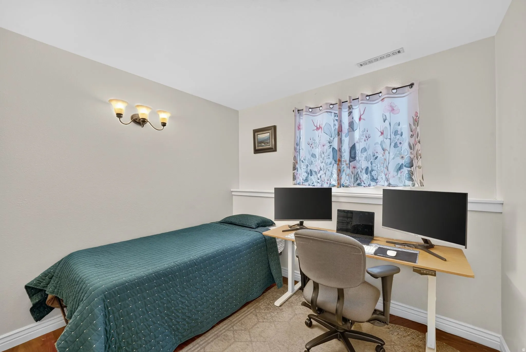 Wall-mounted light fixture, window with curtains, and wood-finish flooring