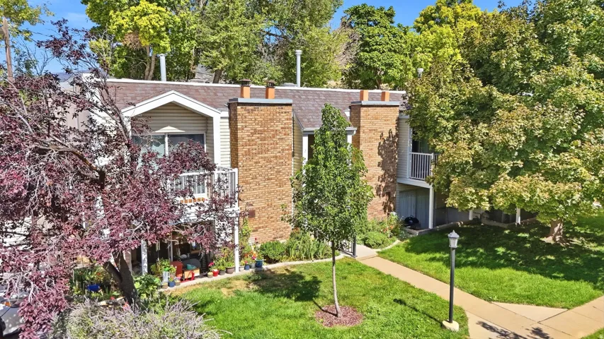 Multi-level residence featuring a brick chimney and white siding
